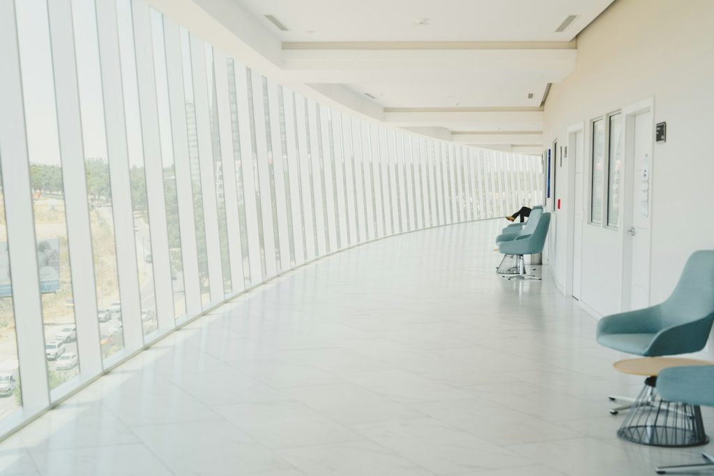 A long hallway with a row of chairs next to a wall
